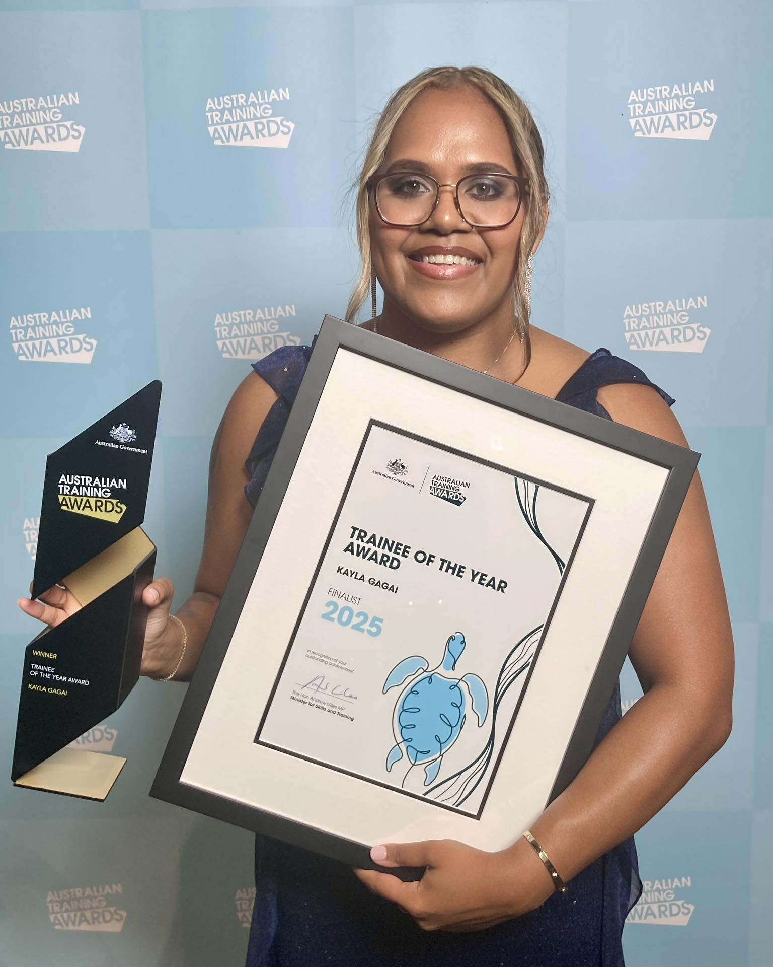 image of trainee of the year Kayla Gagai holding a certificate and a trophy at the Australian Training Awards 2025
