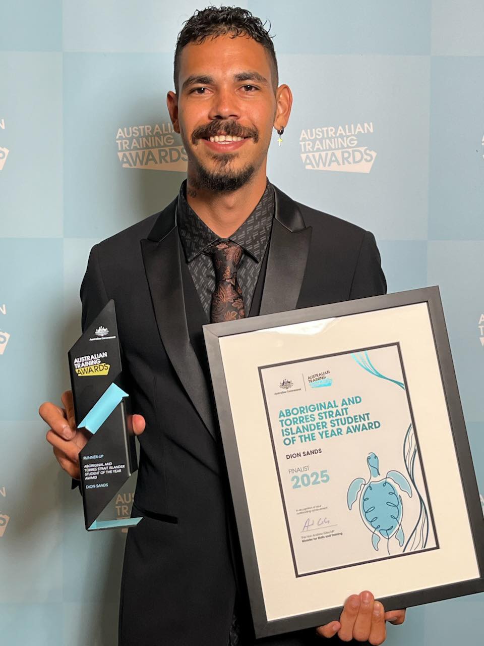 Dion Sands (male adult) at the Australian Training Awards holding a certificate and a trophy