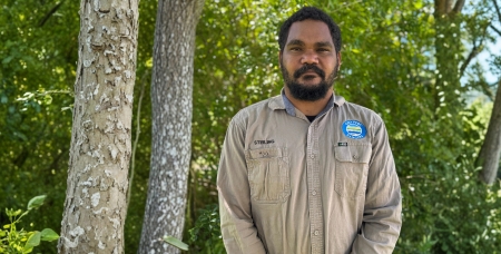 Image of Stirling Ludwick, young First Nations man, standing outside in his ranger uniform